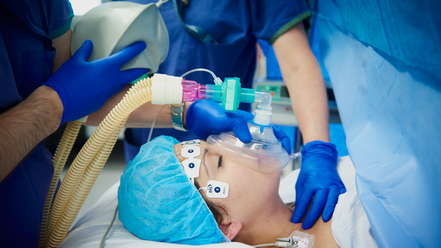 Photo of patient in hospital bed being anaesthetised