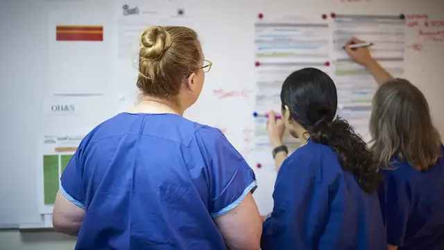 A team of healthcare professionals collaborates on a clinical research board, analyzing data and refining protocols to enhance patient outcomes in anaesthesia and perioperative care.