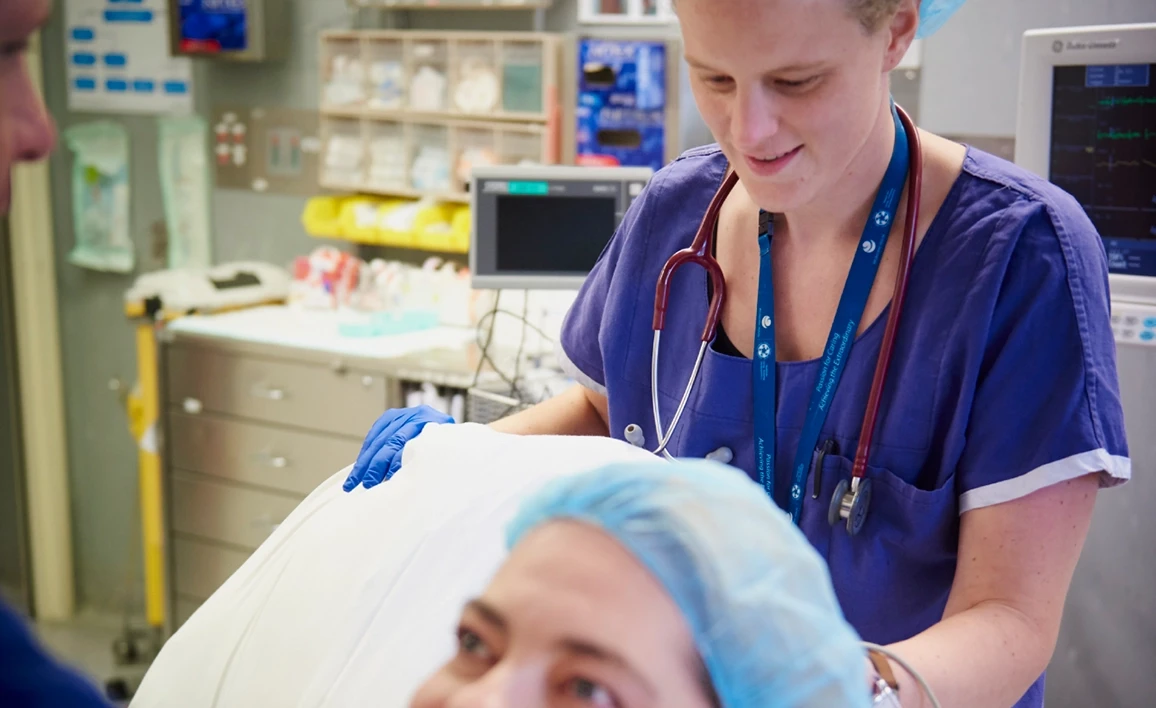 Doctor standing behind patient on bed
