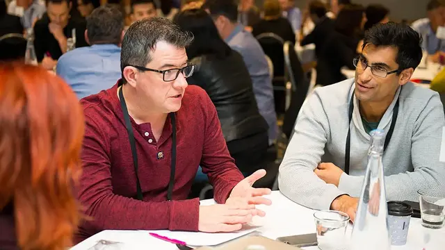 Professionals engaged in discussion around a table