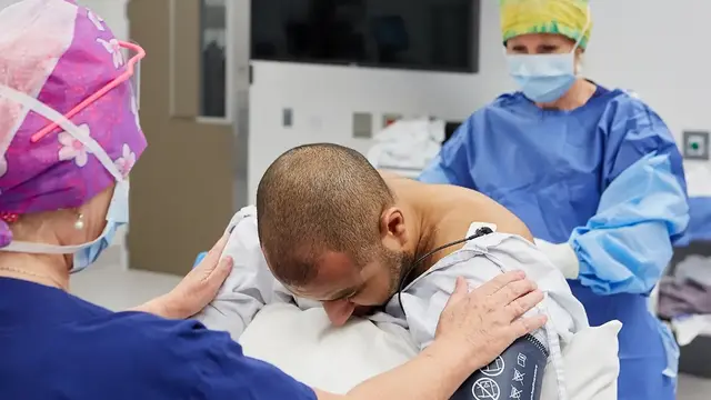 Two doctors conducting a procedure with a patient