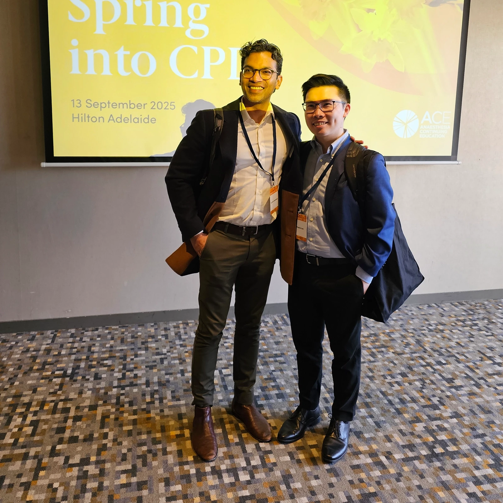 Two people standing in front of screen