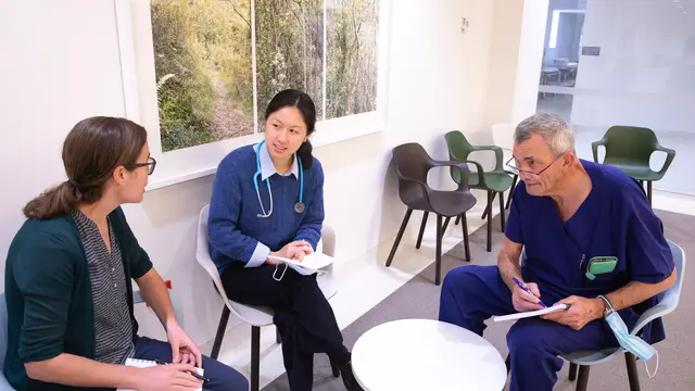 Doctors talking to each other with notepads