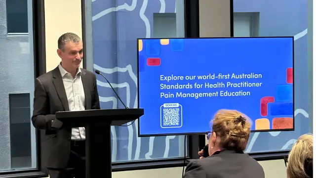 Dr Noam Winter presenting the standards at a podium
