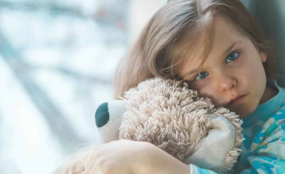 Small child holding a teddy