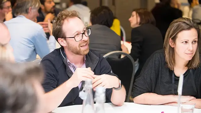 A group of professionals engaged in a discussion at a round table.