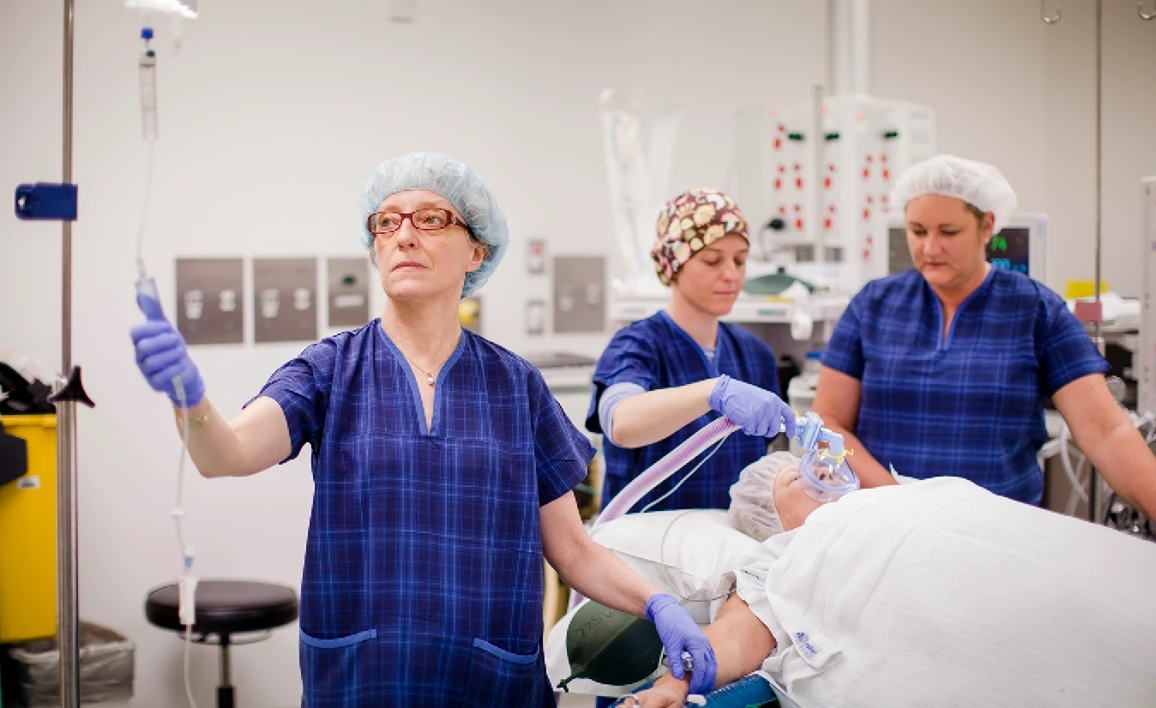 Anaesthetists surrounding patient in operating theatre