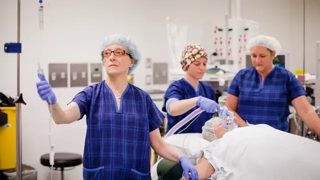 Anaesthetists surrounding patient in operating theatre 