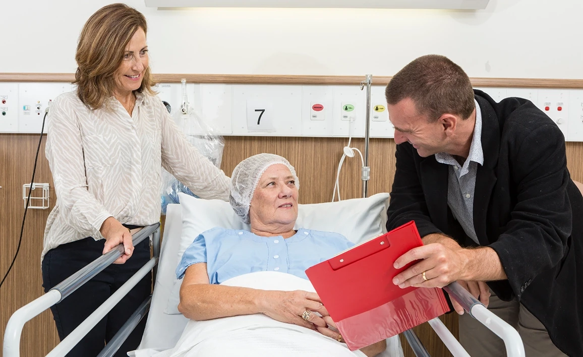 Doctor talking to patient on bed