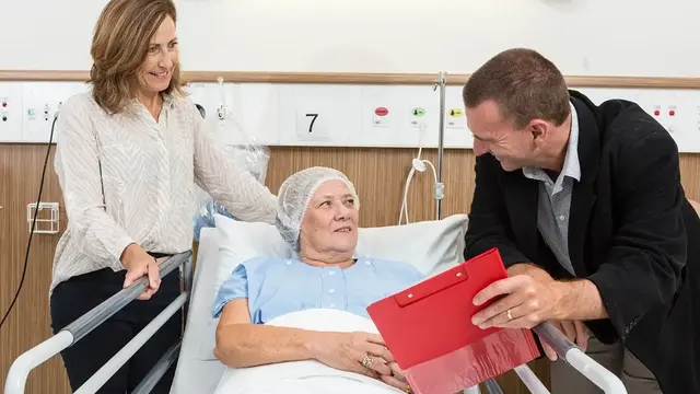 Doctor talking to patient on bed