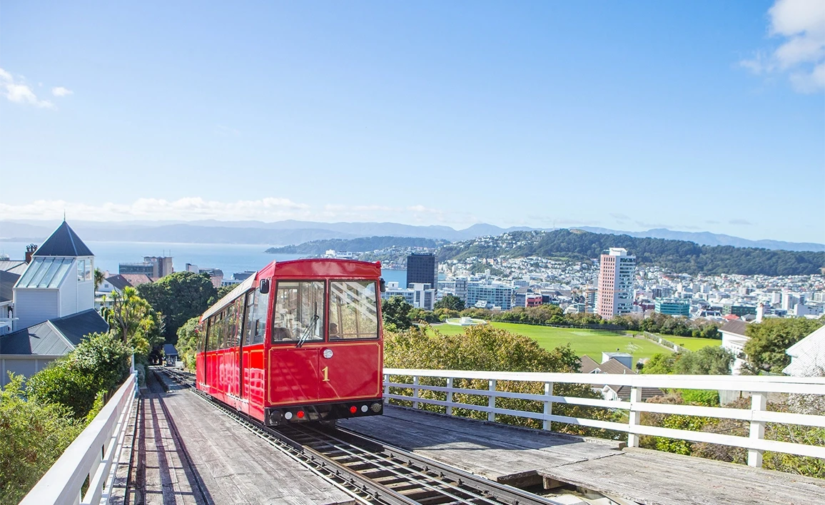 Red cable car with view of Wellington city